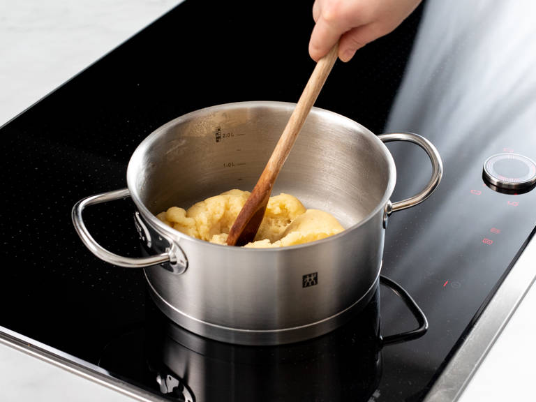 To make the choux pastry, add milk, butter, sugar, and a pinch of salt to a saucepan and bring to a boil over medium heat. Add flour and stir constantly until you have a very thick batter. Once a thin floury coating forms on the base of the saucepan, it’s ready. Remove from heat, transfer to the bowl of a stand mixer, and mix slowly for approx. 3 – 4 min. to allow the mixture to cool down. Add eggs one at a time, beating between each addition, until well combined.